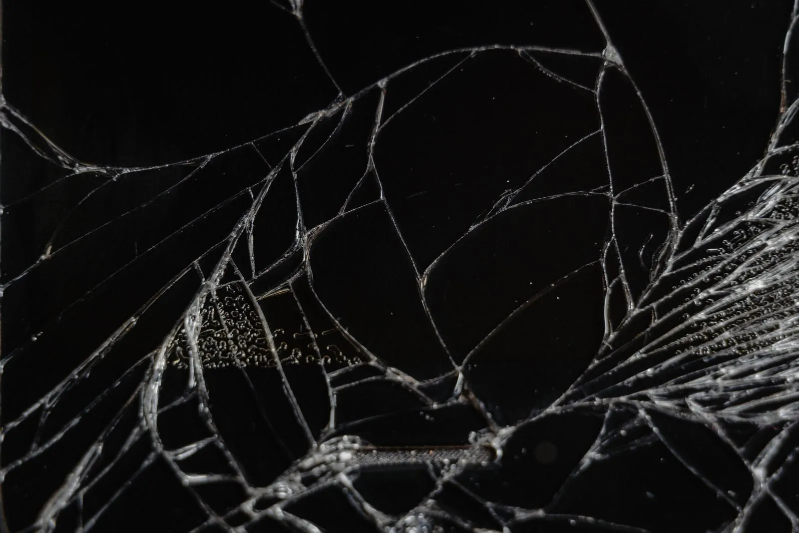 Close-up view of shattered glass showing delicate fragments and patterns.
